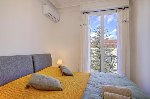 une chambre avec un lit avec des oreillers et une fenêtre dans l'établissement Maison Bianchi - Avenue Durante - Downtown Top floor, à Nice
