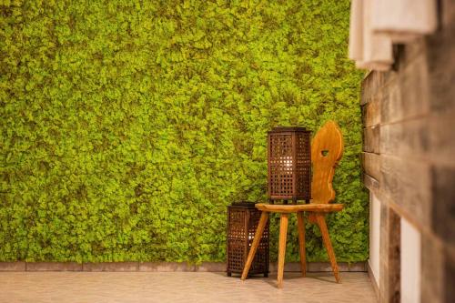 a wooden chair in front of a green wall at Familien- & Vitalhotel Auenhof in Fulpmes
