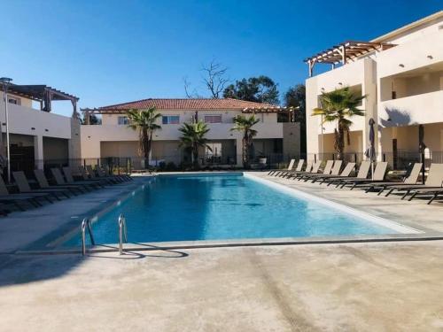 une grande piscine devant un immeuble dans l'établissement marina di bravone - corse - linguizzetta, à Linguizzetta