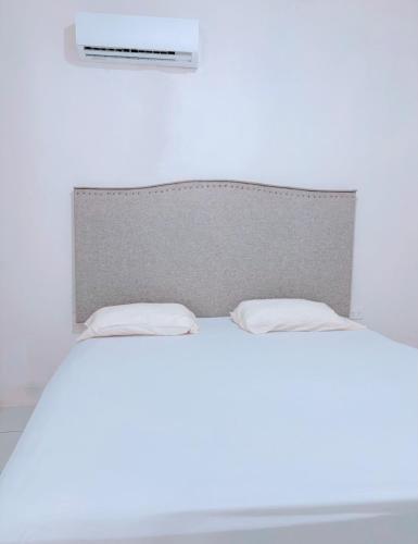 a white bed with two pillows on top of it at Loft teba near Tapachula airport in Tapachula