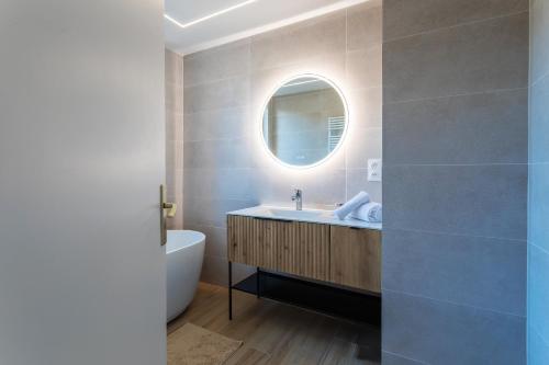 une salle de bain avec un lavabo, une baignoire et un miroir dans l'établissement LE SAINT ESTEVE AP4435 By Riviera Holiday Homes, à Villefranche-sur-Mer