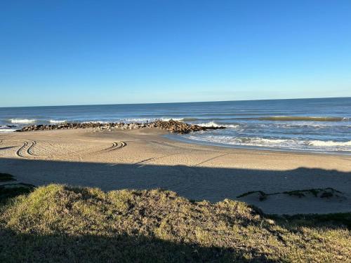a sandy beach with the ocean in the background at Ph Completo Petfriendly in Mar del Plata