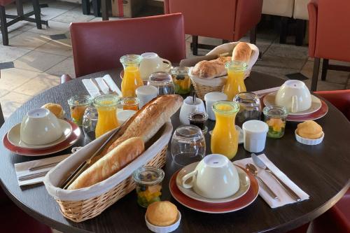 een tafel met een ontbijt van brood en jus d'orange bij Chambre d'hôtes option étape pour professionnel in Morangis