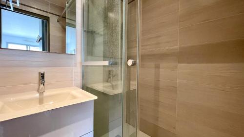 une salle de bain avec un lavabo et une douche en verre dans l'établissement Incroyable vue mer et accès plage !, à Antibes