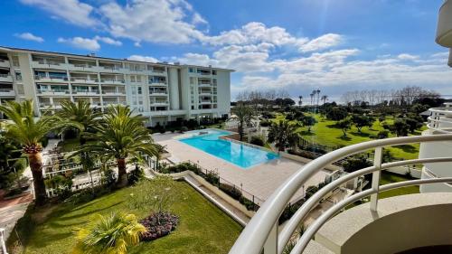 - un balcon dans un bâtiment avec piscine et palmiers dans l'établissement Incroyable vue mer et accès plage !, à Antibes