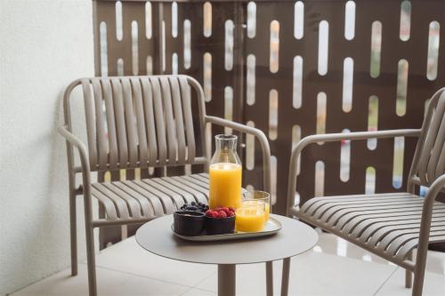 a table with a plate of fruit and a bottle of orange juice at Luxury Sunny Home - Free Garage, Metro, Balcony, PS5, 2nd parking on request in Prague