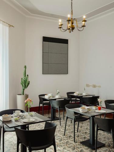 een eetkamer met tafels en stoelen en een kroonluchter bij Villa Verlengia in Montesilvano