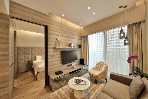 a living room with a couch and a television at Pan Pacific Serviced Suites Beach Road, Singapore in Singapore