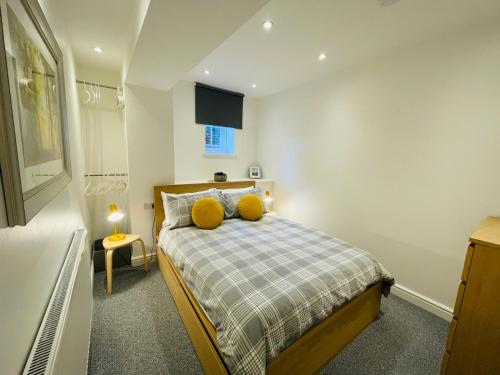 a bedroom with a bed with two yellow pillows at Pass the Keys Converted Sunday School for 4 with Views & Garden in Taxal