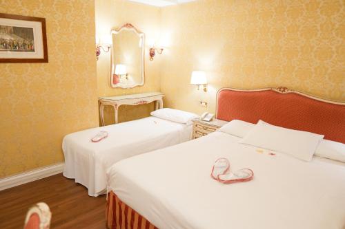 a hotel room with two beds with hearts on them at Hotel Antiche Figure in Venice