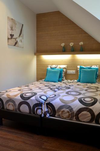 une chambre avec un grand lit avec des oreillers bleus dans l'établissement Auberge La Douce Montagne, à Allemont