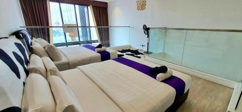 a hotel room with three beds and a large window at M CITY AMPANG, KLCC pool view in Kuala Lumpur