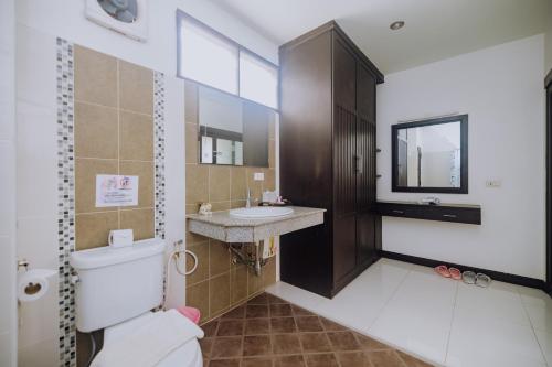 a bathroom with a toilet and a sink and a mirror at Monaburi Boutique Resort in Rawai Beach