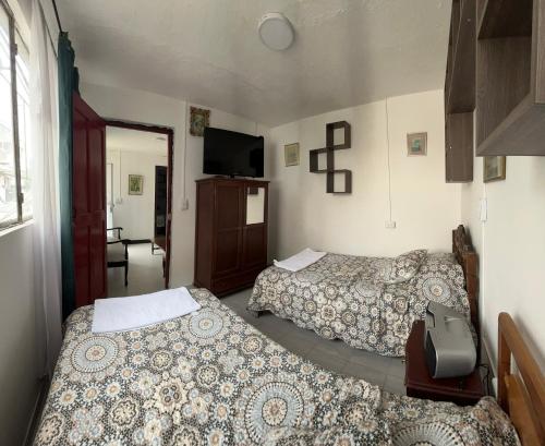 a hotel room with two beds and a television at Carana in Paipa