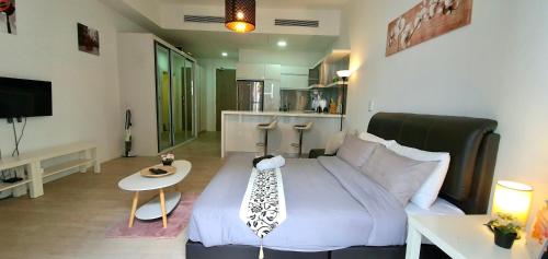 a bedroom with a large bed and a small table at M CITY AMPANG, KLCC pool view in Kuala Lumpur