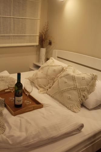 a tray with a bottle of wine and glasses on a bed at Chechar Inn Zlatar in Nova Varoš