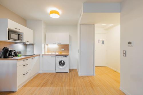 a kitchen with a washer and a washing machine in it at OVELIA Ermont - Le Pavillon d'Amélie in Ermont
