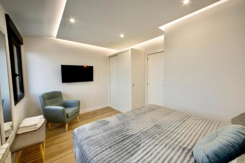 a bedroom with a bed and a chair at Lucus Skyline & Terrace by Lugo Collection in Lugo