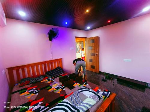 a bedroom with a bed with a person loading a box at Ocean pearl 01 in Kāsarkod