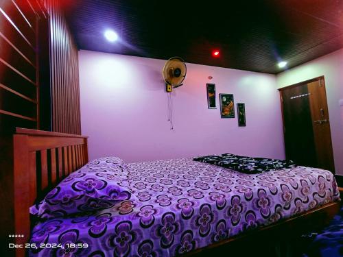 a bedroom with a bed with a purple comforter at Ocean pearl 01 in Kāsarkod