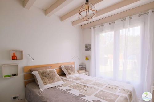 une chambre avec un lit et une grande fenêtre dans l'établissement Biscarrosse Plage Maison de charme proche des plages océanes classé 1, à Biscarrosse