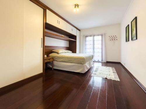 a bedroom with a bed and a wooden floor at Casa espaçosa a apenas 30 minutos de SP in Sao Paulo