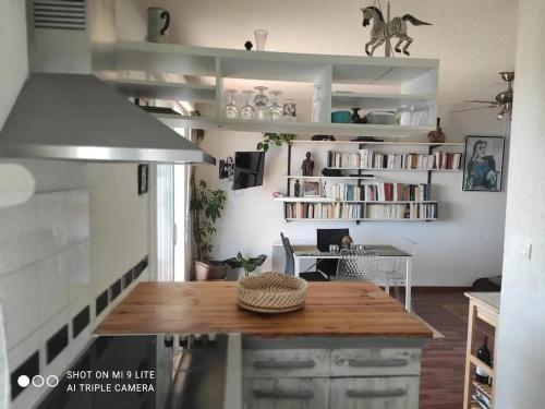 une cuisine avec une table et une étagère. dans l'établissement Appartement moderne à Ajaccio avec vue sur la mer, à Ajaccio