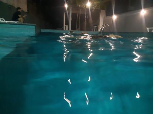 a person swimming in a swimming pool at night at Hospedagem COP30 in Ananindeua