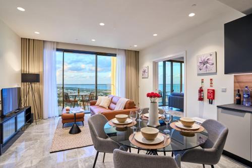 a living room with a table and chairs at Stunning Seaview Mercury Tower Apartments - Luxurious Twin Units in St. Julianʼs