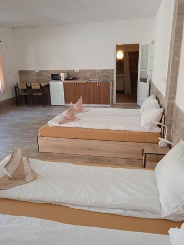 two beds sitting on the floor in a room at R4 Rolléder Apartman-ház in Siklós