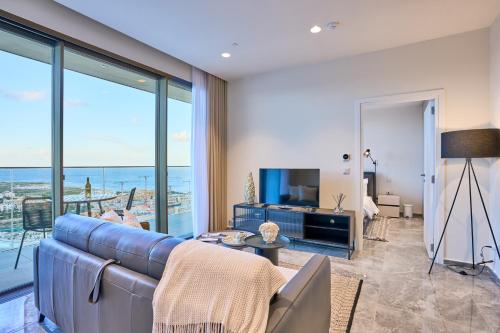 a living room with a couch and a large window at Stunning Seaview Mercury Tower Apartments - Luxurious Twin Units in St. Julianʼs