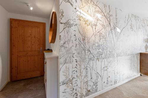 a hallway with a wall mural of plants at Chalet apartment with balcony and Alpine view in Ollon