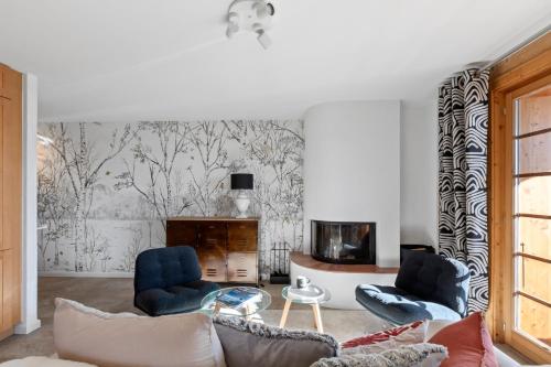 a living room with a couch and chairs and a fireplace at Chalet apartment with balcony and Alpine view in Ollon