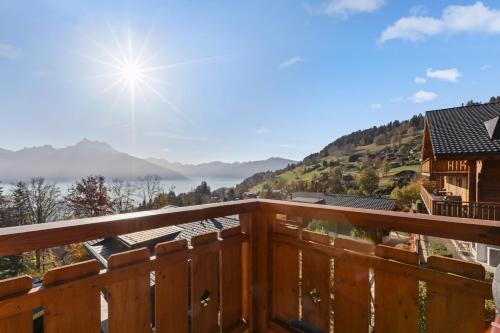 a view from the deck of a house with the sun shining at Chalet apartment with balcony and Alpine view in Ollon