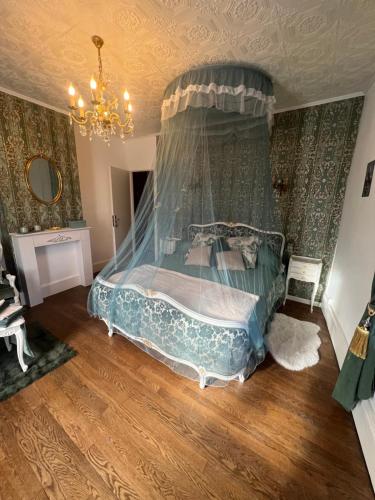a bedroom with a bed with a canopy at Domaine du Rosiere in Favières