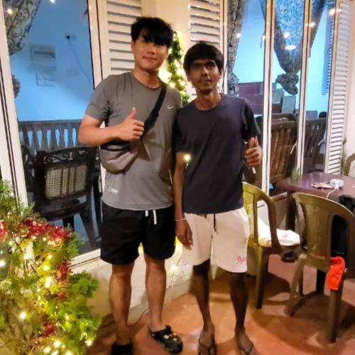 two men standing in front of a christmas tree at Guest house weherahena in Matara