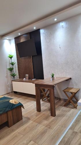 a living room with a wooden table and a couch at Apartments Green Beograd in Borča