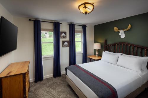 a bedroom with a bed and a flat screen tv at Lodge at Schroon Lake in Schroon Lake