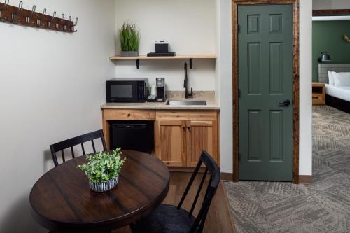 a kitchen with a table and a green door at Lodge at Schroon Lake in Schroon Lake