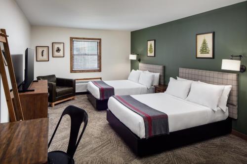 a hotel room with two beds and a flat screen tv at Lodge at Schroon Lake in Schroon Lake