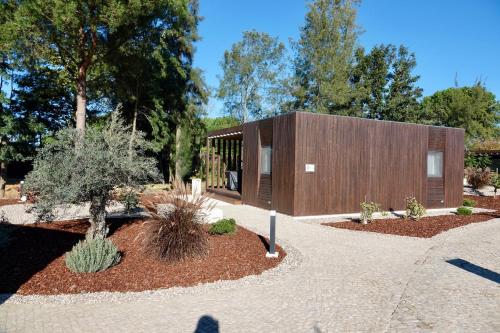 a house with a wooden facade in a garden at Refúgio da Quinta Nere Maitia in Santarém