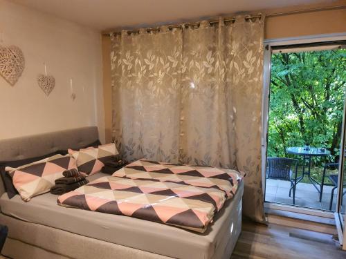 a bedroom with a bed and a window with a patio at Schönes Modernes Apartment in der Nähe vom Bahnhof in Tübingen