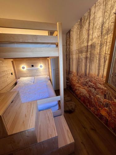 - une chambre avec 2 lits superposés et une fresque murale représentant la forêt dans l'établissement Nid des Cimes, à Valmeinier