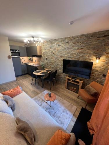 un salon avec un canapé et un mur de briques dans l'établissement Nid des Cimes, à Valmeinier