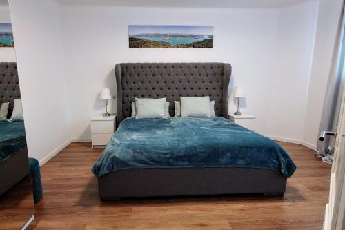 ein Schlafzimmer mit einem großen Bett und zwei Nachttischen in der Unterkunft Villa Kreuzbergl - Apartment in Klagenfurt am Wörthersee
