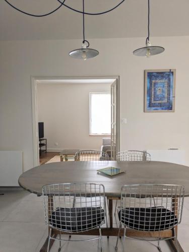 a dining room with a table and chairs at La maison bleue in Dijon
