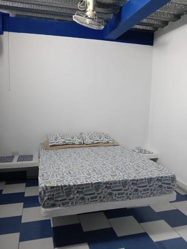 a bed in a room with a white wall at Casa Skyros in Arboletes