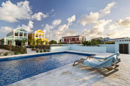 a swimming pool with a chair and some houses at Casa Blue Marlin (1e verdieping) in Kralendijk