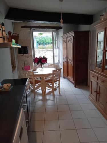 - une cuisine avec une table et des fleurs dans l'établissement Saint-Gervais, à Lectoure