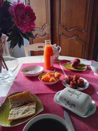 - une table avec des assiettes de nourriture et une carafe de jus d'orange dans l'établissement Saint-Gervais, à Lectoure